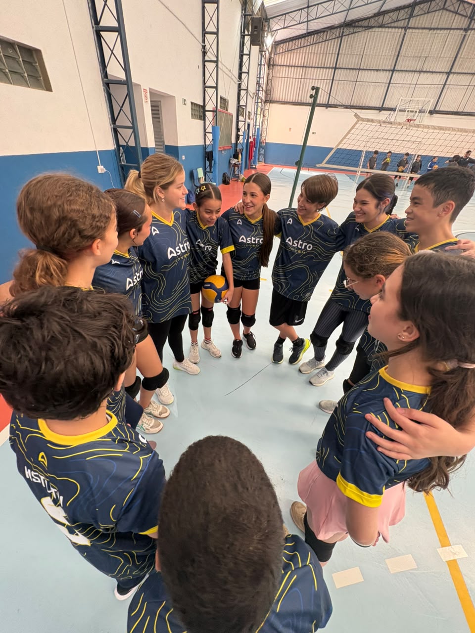 Time da Astro Jovem abraçado em roda com a professora